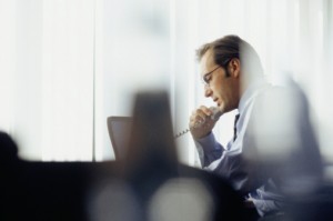 A businessman considering a document on his computer.